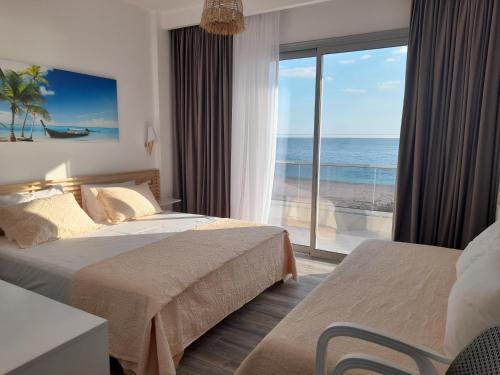 希马拉Anxhelos Hotel的酒店客房设有两张床,享有海景。