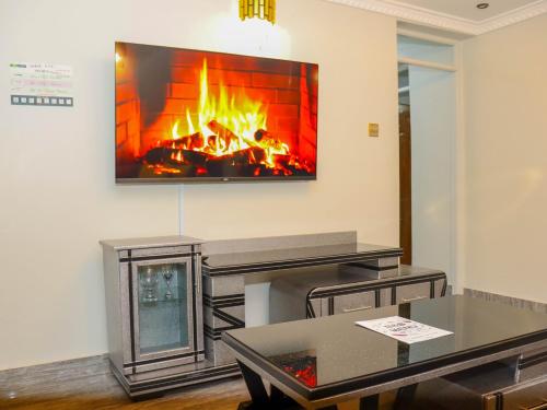 奈瓦沙Weber Generations Accommodation的客厅设有壁炉,墙上配有电视。