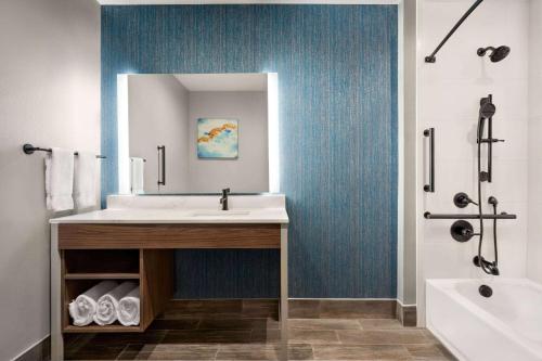 德尔里奥La Quinta Inn & Suites by Wyndham Del Rio的浴室配有盥洗盆、镜子和浴缸