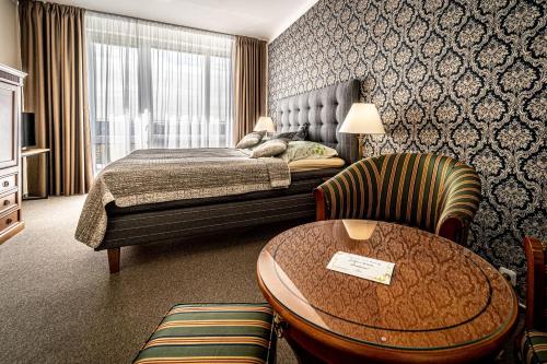 布尔诺Hotel Fontána的酒店客房,配有一张床、一张桌子和椅子