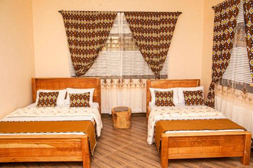 莫希Materuni Homes的一间卧室设有两张床,窗户配有窗帘