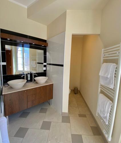 科蒂尼亚克Hôtel La Falaise的一间带两个盥洗盆和大镜子的浴室