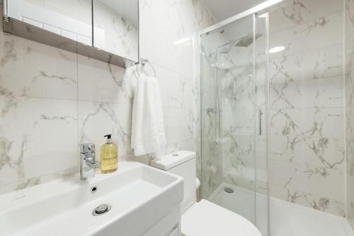 依尔福Modern 2 Bedroom Flat in Ilford, London的一间带水槽、卫生间和淋浴的浴室
