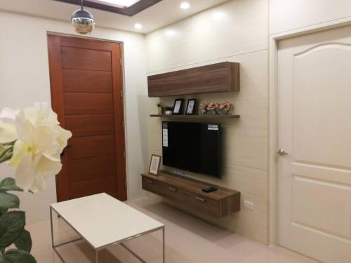 马尼拉Adria Residences - Emerald Garden - 2 Bedroom Unit for 4 person的客厅的墙上配有电视