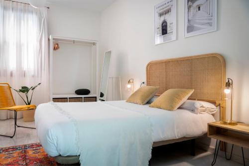 塞维利亚MonKeys Apartments Alameda House的卧室配有一张带两个枕头的大白色床
