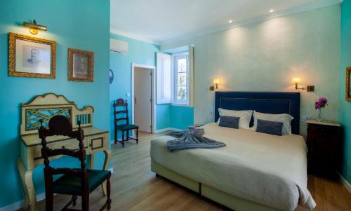 辛特拉辛特拉宫精品住宿加早餐旅馆的一间卧室设有蓝色的墙壁、一张床和一张书桌