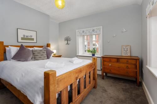 利物浦Air Host and Stay - Anfield cottage, 2 bedroom 2 bathroom的一间卧室配有一张大型木床和一个梳妆台。