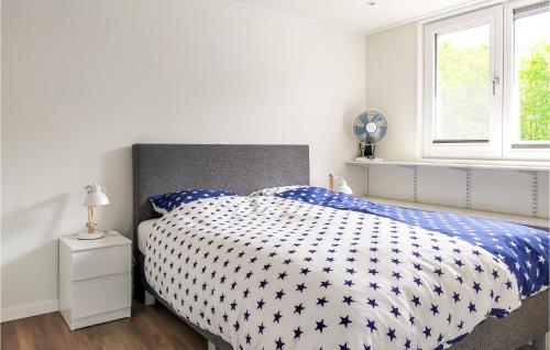 De HeenAwesome Home In De Heen With Wifi的一间卧室配有一张带蓝色和白色棉被的床