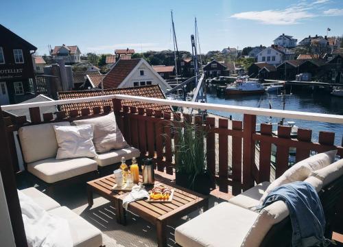 卡琳贡Hotell Käringön的阳台配有沙发和一张带饮品的桌子。