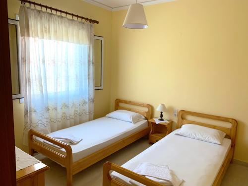 阿齐欧斯·贡多斯Spiros Apartments - Agios Gordios Beach, Corfu, Greece的带窗户的客房内设有两张单人床。