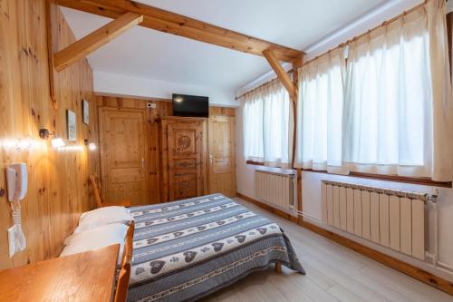 塞拉克卡斯卡德Spa酒店的卧室配有一张床铺,位于带木墙的房间内