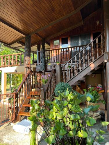 Ban Chak PhaiTraditional Thai house บ้านเรือนไทย ใกล้หาดระยอง的前方有木楼梯的房屋