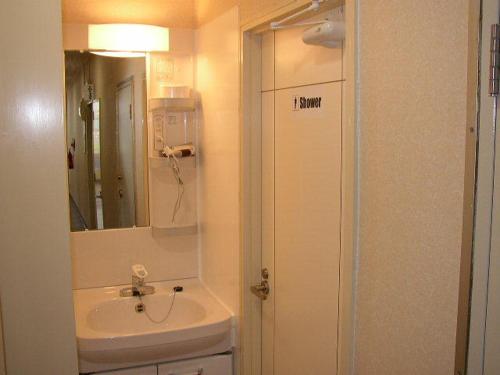 那霸那霸格雷斯酒店的白色的浴室设有水槽和镜子