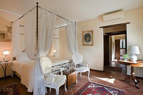 纳尔尼Torre Palombara - Dimora Storica的一间卧室配有一张天蓬床和两把椅子