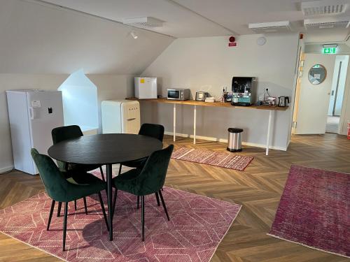 布罗斯Mini-Hotel Borås Regementet的配有桌椅和厨房的房间