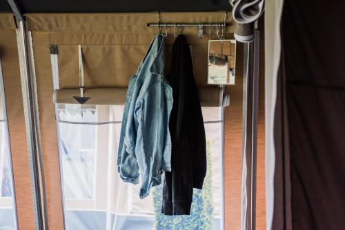 维亚雷焦Country Camp Campeggio Paradiso的一间设有滑动玻璃门和挂衣服的房间