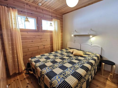 索特Kärpänpesä B的卧室配有一张床铺,位于带木墙的房间内