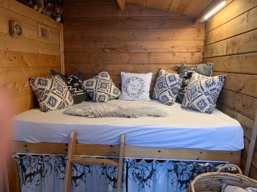 科克赛德Bed & breakfast Duna met hammam, jacuzzi, sauna的小木屋内的一张床位,配有枕头