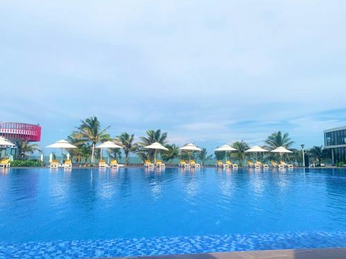 隆海Oceanami Villa Long Hải - Vũng Tàu的一个带椅子和遮阳伞的大型游泳池