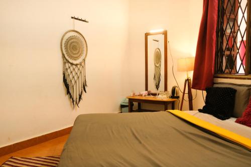 瓦加托Mitra Hostel Vagator的卧室配有一张床铺,墙上装有风扇