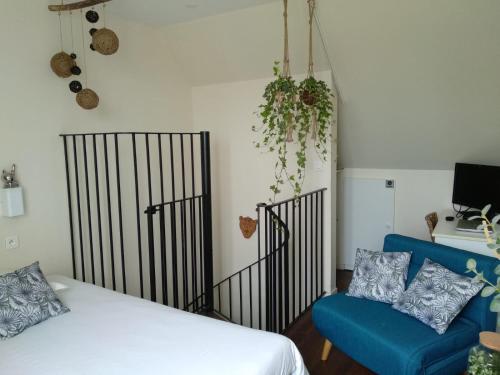 吉代勒Charmant logement vue mer avec chambre et terrasse的一间卧室配有一张床和一张蓝色的沙发