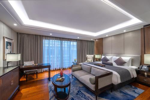 吉达Narcissus Obhur Resort & Spa的酒店客房配有一张床、一张沙发和一张书桌。