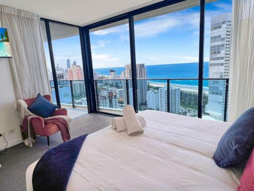黄金海岸29th floor Oracle Tower 2 stunning ocean and city views的卧室设有一张白色大床和大窗户