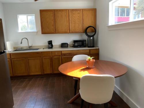 圣马科斯Boulder Bluff Inn的厨房配有木桌和白色椅子