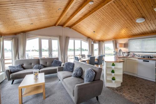 塔特舍尔Tattershall Lakes Country Park的带沙发的客厅和带窗户的厨房