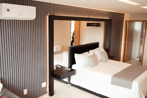 塔瓜汀加Miami Hotel by H Hotéis - Business的酒店客房,配有床和镜子