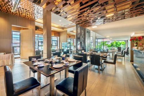 曼谷曼谷M2酒店的用餐室设有桌椅和窗户。