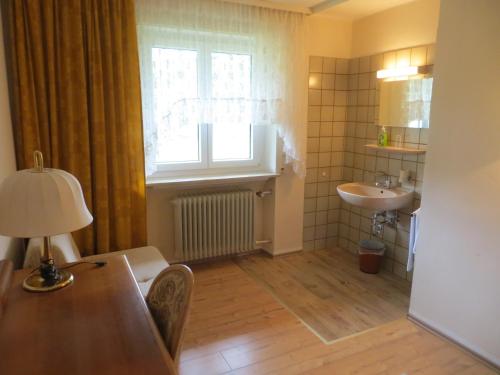 博伊龙Gäste- und Tagungshaus Maria Trost的一间带桌子、水槽和窗户的浴室