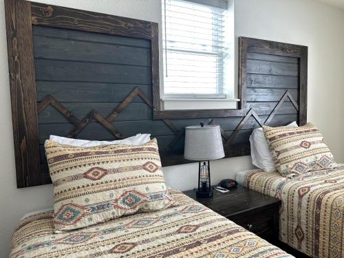 EncampmentPine Lodge的一间卧室设有两张床、床头板和一盏灯。