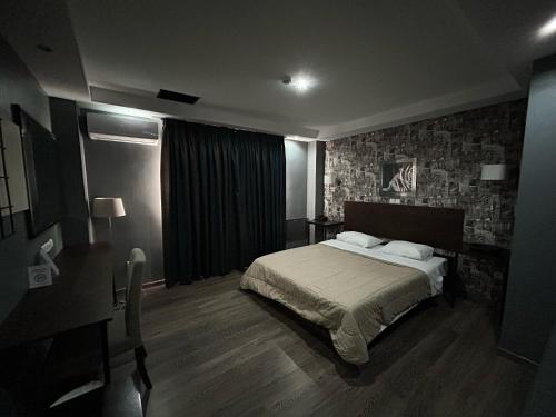 塞尔米雅典娜机场酒店的一间卧室配有一张床、一张桌子和一张书桌