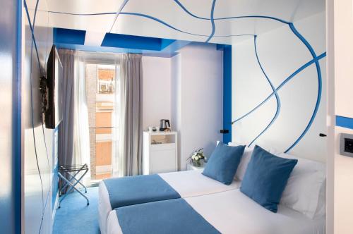 巴塞罗那Allegro Barcelona的卧室配有白色的蓝色调床。
