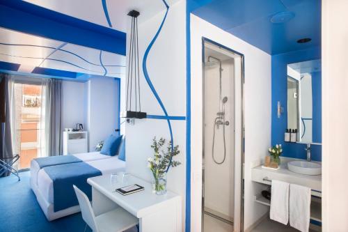 巴塞罗那Allegro Barcelona的一间蓝色的卧室,配有一张床和一间浴室