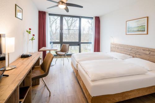 菲尔斯滕瓦尔德斯普雷勃艮酒店的酒店客房配有一张床、一张书桌和一张书桌。