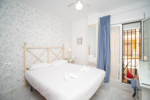 桑卢卡尔-德巴拉梅达Sol y Vida, Apartamentos Living Sur的白色的卧室设有床和窗户