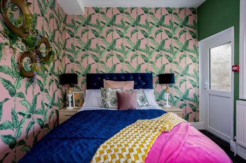 克利夫利斯Charles Alexander Short Stay - Botanical House的一间卧室配有一张绿色和粉红色壁纸的床