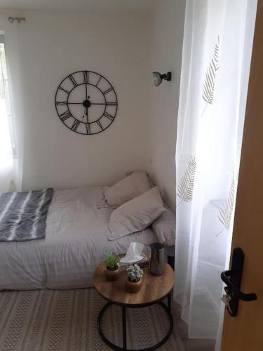 菲雅克Superbe petit studio plein centre ville的卧室配有一张床,墙上挂着一个钟