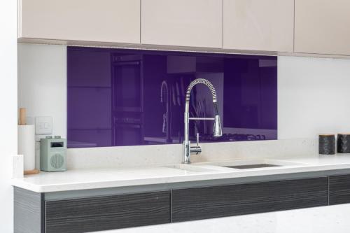 巴斯Fabulous House - Only 10 minutes walk to Roman Baths的一个带水槽和紫色橱柜的厨房台面
