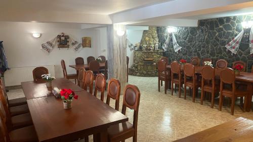 Podu lui NeagCabana Perla Munților - Valea Doftanei的用餐室配有木桌和椅子