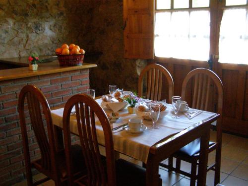 TriongoCASA ALDEA LOS CASTAÑOS的一张带椅子的木桌和一张带水果的桌子