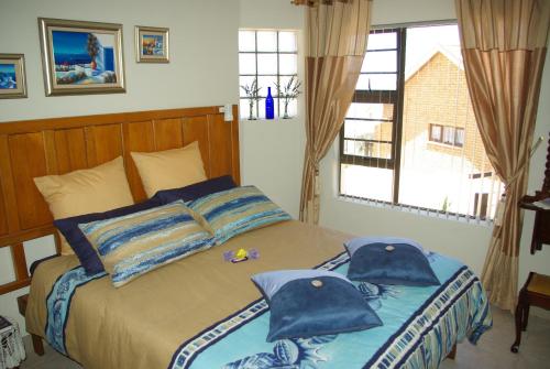 赫罗德斯湾The Third Dolphin的一间卧室配有一张带两个蓝色枕头的床