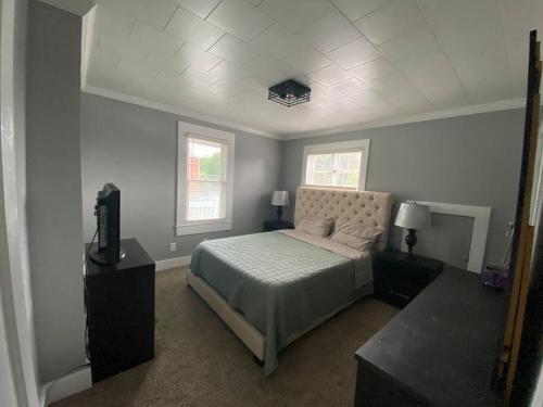 迪比克3bed 2bath nestled in cozy Grandview neighborhood的一间卧室设有一张床和两个窗户。