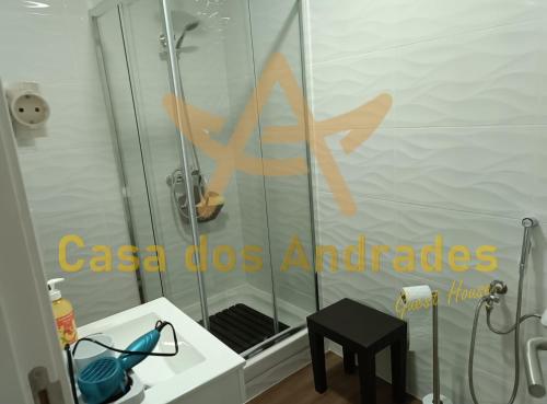 贝尔蒙特Casa dos Andrades的浴室设有玻璃门和凳子淋浴