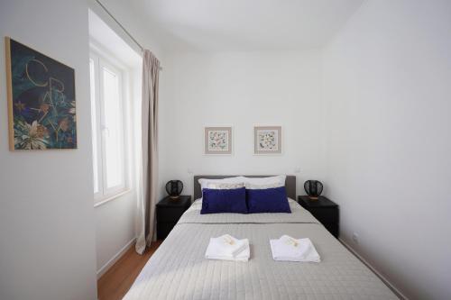 里斯本Apartment Ajuda Tagus River View的白色卧室,配有带2条白色毛巾的床