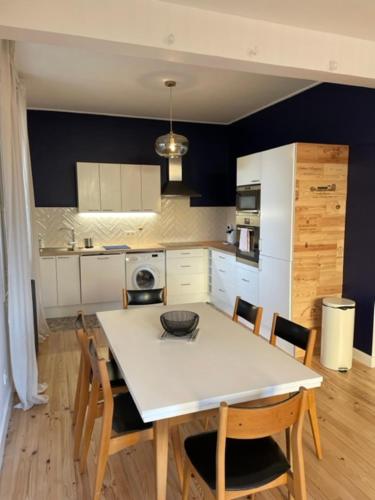 米洛Maison rouge的一间带白色桌椅的厨房和一间带蓝色墙壁的厨房