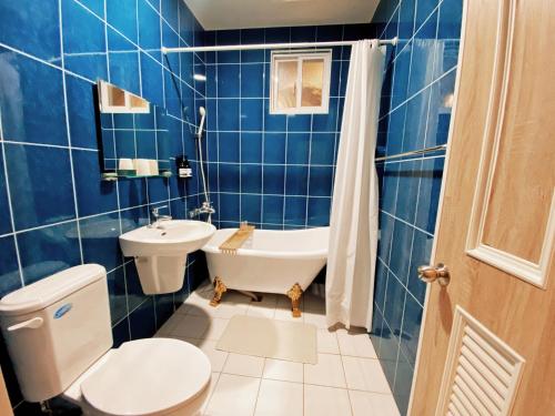 恒春古城麋宿Mi House墾丁包棟的蓝色瓷砖浴室设有卫生间和水槽