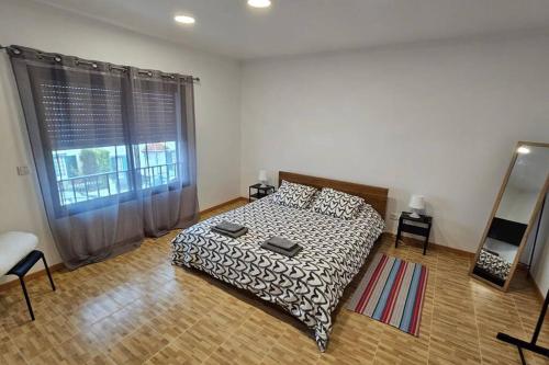 蓬塔德尔加达Casa da Relva的一间卧室设有一张床和一个大窗户